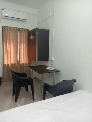 a bedroom with a table and chairs and a bed at bohom STAYORA in Nedumbassery