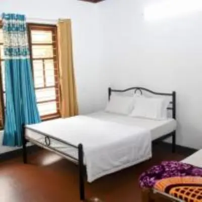 a bedroom with a bed and a window at Coorg mansion in Madikeri