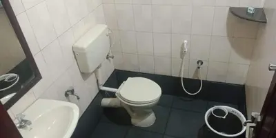 a small bathroom with a toilet and a sink at Mahe Residency in Mahe