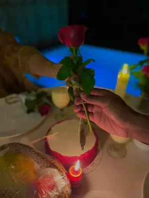 a person holding a rose on top of a cake at Hayashi Resort in Meppādi