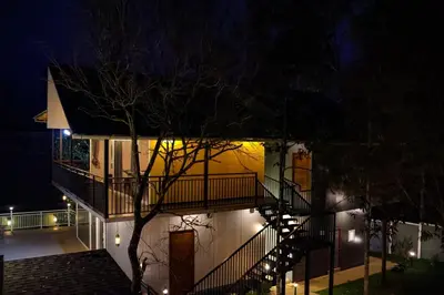 a building with a staircase in front of it at night at Hayashi Resort in Meppādi
