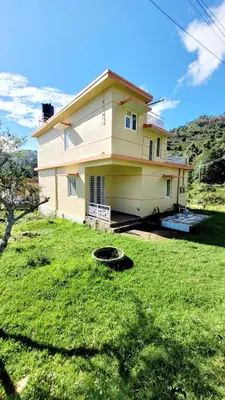 a house with a grassy yard in front of it at Zirku Garden Kodaikanal in Kodaikānāl