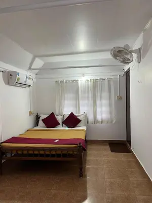 a bedroom with a bed with red pillows and a window at Relax inn cherai beach in Cochin
