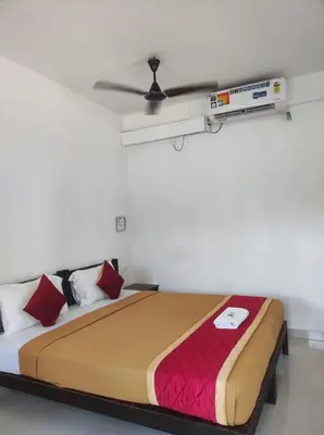 a bedroom with a large bed with red pillows at Relax inn cherai beach in Cochin