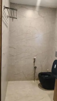 a bathroom with a black toilet and a shower at LA VILLA VYTHIRI Resort in Vythiri