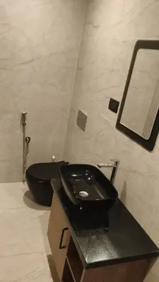 a bathroom with a black toilet and a sink at LA VILLA VYTHIRI Resort in Vythiri