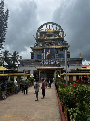 a group of people walking around a building at Kannada Maathe Home Stay- Golden Temple-Tibet camp 2 km far in Kushālnagar