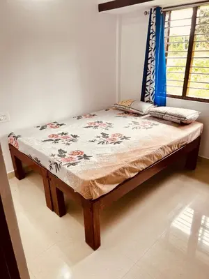 a large bed in a room with a table at Kannada Maathe Home Stay- Golden Temple-Tibet camp 2 km far in Kushālnagar
