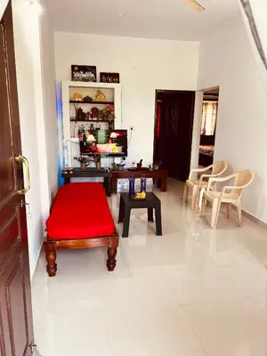 a living room with a red bench and a table at Kannada Maathe Home Stay- Golden Temple-Tibet camp 2 km far in Kushālnagar