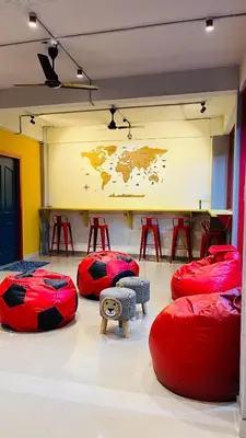 a room with red bean bags and a map of the world at Tokyo Dorms in Kozhikode