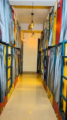 a hallway of a room with colorful racks of clothing at Tokyo Dorms in Kozhikode