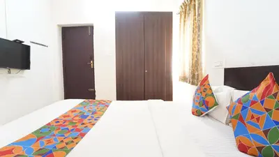 a bedroom with a white bed with colorful pillows at Honey Residency Codissia stay in Coimbatore