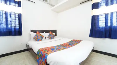 a bedroom with two beds and blue curtains at Honey Residency Codissia stay in Coimbatore