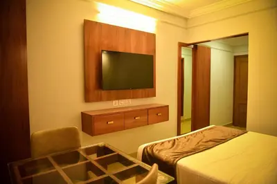 a hotel room with two beds and a television at Hotel Manal Suites in Green Island