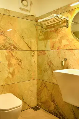 a bathroom with a toilet and a sink at Hotel Manal Suites in Green Island