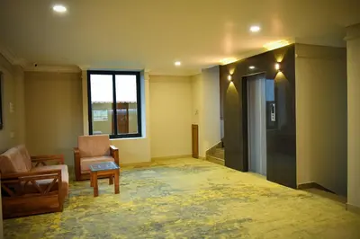 an empty room with a chair and a couch and a window at Hotel Manal Suites in Green Island