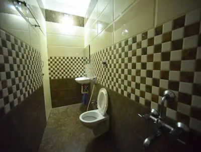 a bathroom with a toilet and a sink at PRM Aruna Lodge in Erode