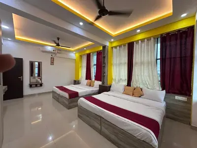 two beds in a room with yellow and red curtains at J TEN Residency in Meenangadi