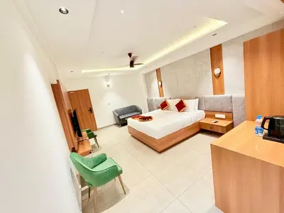 a hotel room with a bed and a couch at Denz Paradise in Kelakam