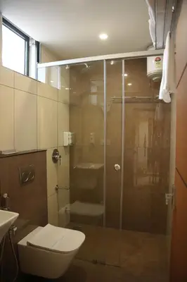 a bathroom with a shower with a toilet and a sink at Denz Paradise in Kelakam