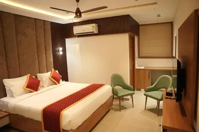 a hotel room with a bed and two chairs at Denz Paradise in Kelakam