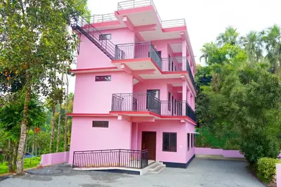 a pink building with stairs and balconies on it at Voyagers Nest Wayanad in Ambalavayal