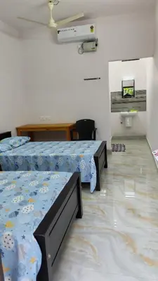 a room with two beds and a tv in it at Voyagers Nest Wayanad in Ambalavayal