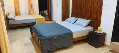 a hotel room with two beds and a mirror at Wayanad Home stay in Kaniyāmbetta