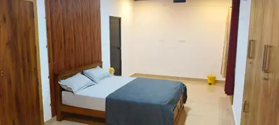 a bedroom with a bed with a blue blanket at Wayanad Home stay in Kaniyāmbetta