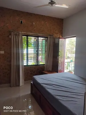 a bedroom with a bed and a large window at Sumukh's house in Mysore