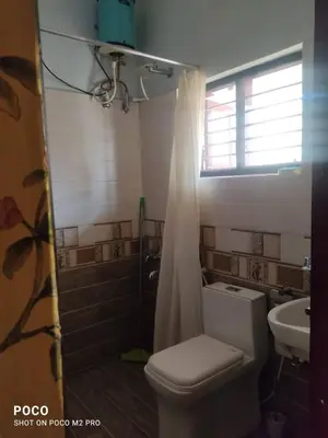 a bathroom with a toilet and a shower and a sink at Sumukh's house in Mysore