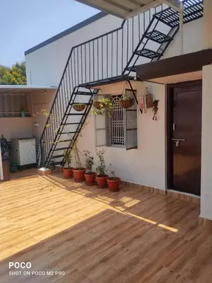a balcony with potted plants and a stair case at Sumukh's house in Mysore