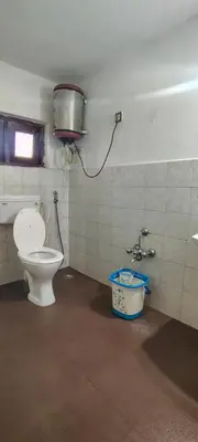 a bathroom with a toilet and a bucket in it at HILL view ooty HOME Stay in Coimbatore