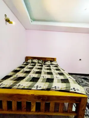 a bed in a room with a checkered mattress at Mysore City Vibe By A1k in Mysore