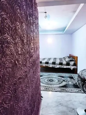 a room with a purple wall with a bed in it at Mysore City Vibe By A1k in Mysore