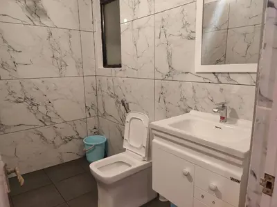 a bathroom with a white toilet and a sink at 3 BHK Flat for rent at Mysuru in Mysore