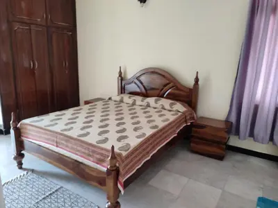 a bedroom with a bed and a wooden bed frame at 3 BHK Flat for rent at Mysuru in Mysore