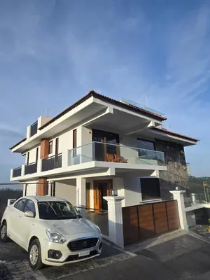 a white car parked in front of a house at Indhraprashtham in Aruvankadu