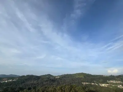 a view of a mountain with trees and a sky at Indhraprashtham in Aruvankadu
