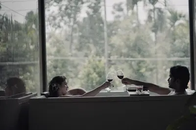 a group of people sitting in a bath tub with wine glasses at Calithra Boutique Resort in Chithragiri