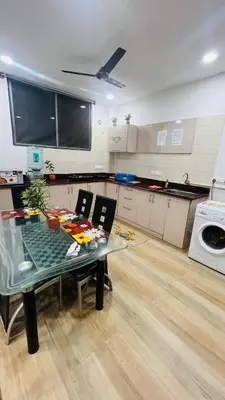 a kitchen with a table with chairs and a microwave at SKYRIN Bliss in Mysore