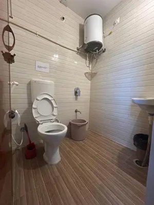 a bathroom with a toilet and a sink at SKYRIN Bliss in Mysore