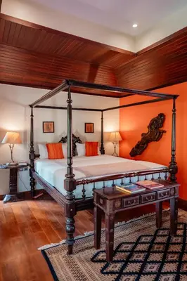 a bedroom with a bed with an orange wall at Madilina Heritage Villa in Parūr