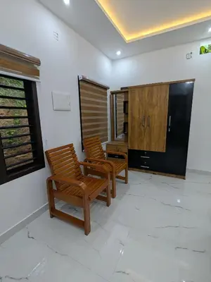 two chairs in a living room with a television at Gods Gift Homestay James Inn in Kozhikode