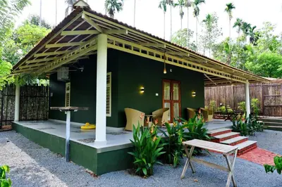 a green house with a wooden roof at Mcafe Private Pool Plantations by Greenescapes in Kenichira