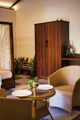 a living room with a table and chairs at Mcafe Private Pool Plantations by Greenescapes in Kenichira