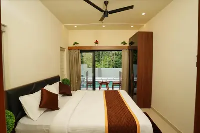 a bedroom with a bed and a dining room at LA VILLA Resort in Vythiri