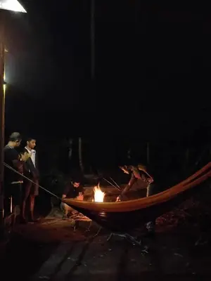 a group of people standing around a fire pit at night at Calm Ville in Ponnampet