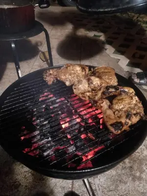 two pieces of meat cooking on a grill at Calm Ville in Ponnampet