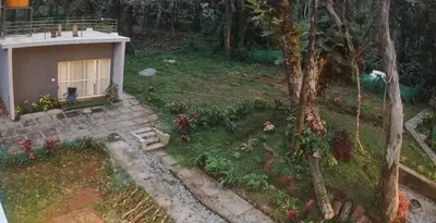 a small house with a bird sitting in a yard at Calm Ville in Ponnampet